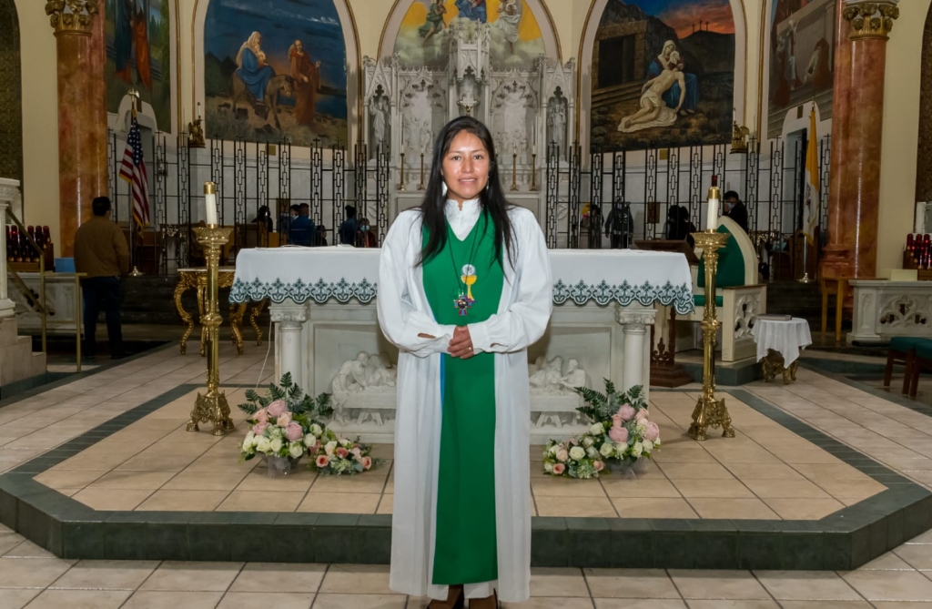 A woman in green and white standing next to a church altar.