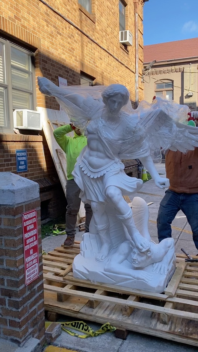 A statue of an angel is being moved.