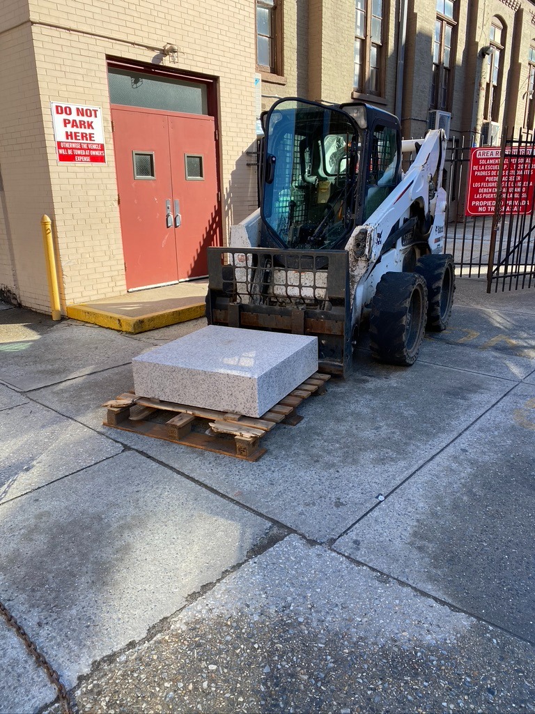 A man is loading a pallet with concrete.