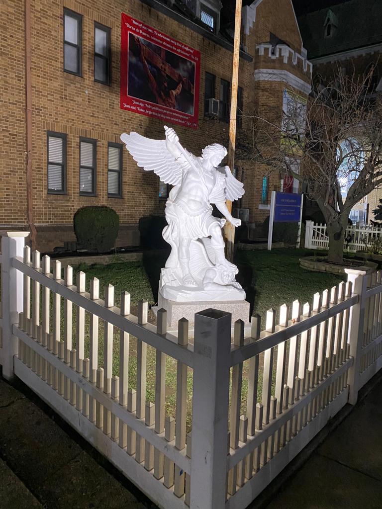 A statue of an angel in front of a building.