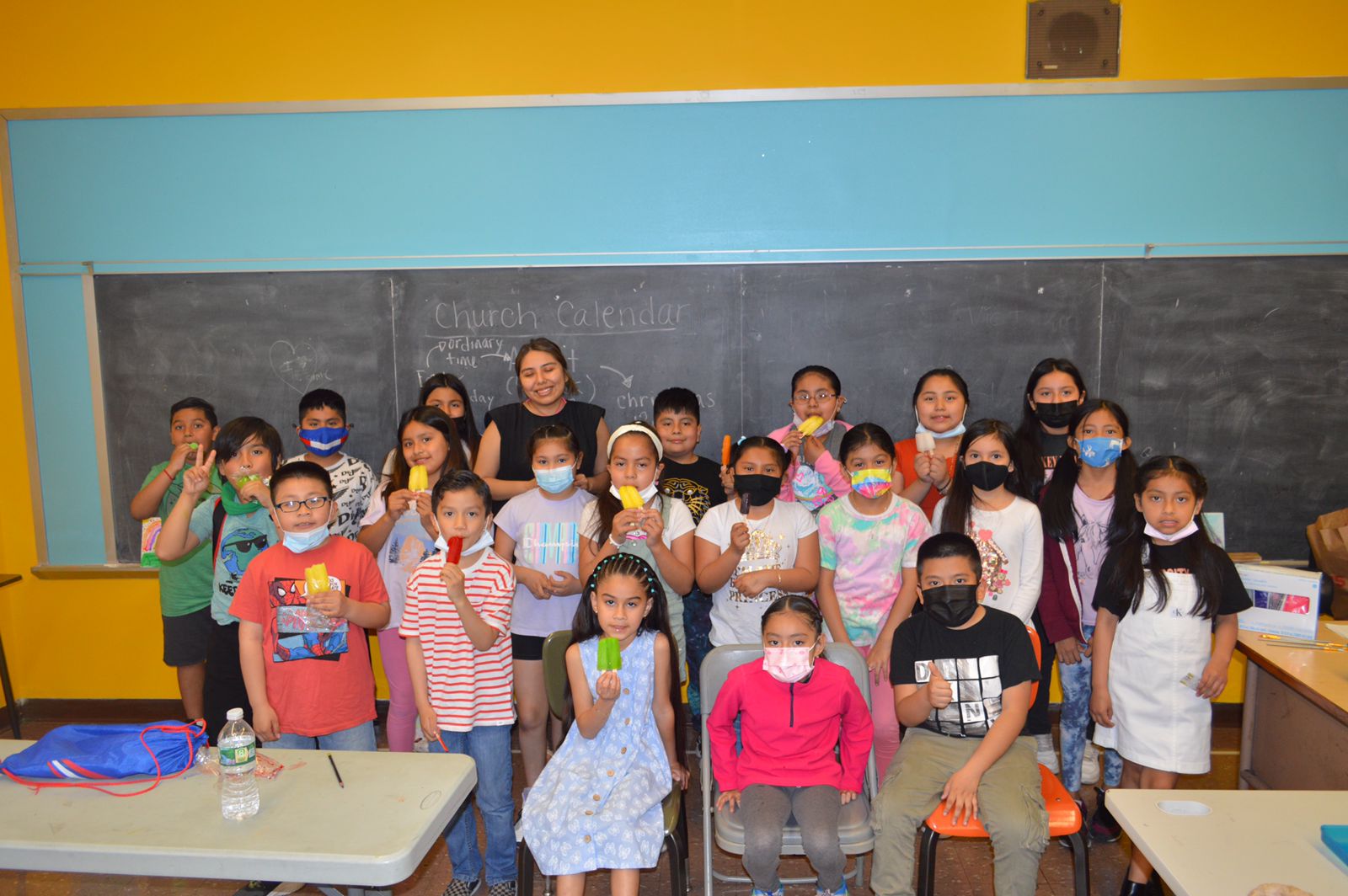 A group of children and adults wearing masks.