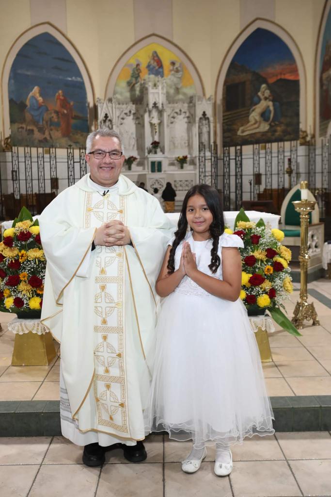 A young girl and her father in front of the altar.