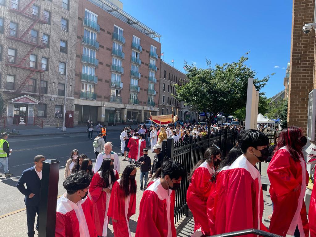 A group of people in red robes walking down the street.