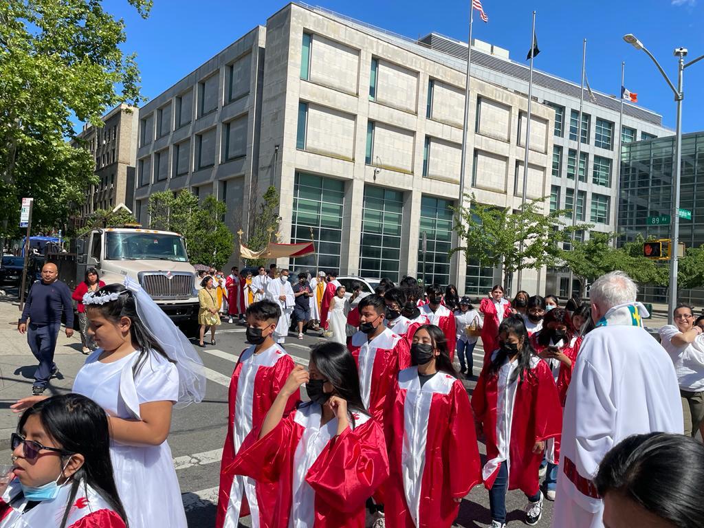 A group of people in red and white robes on the street.