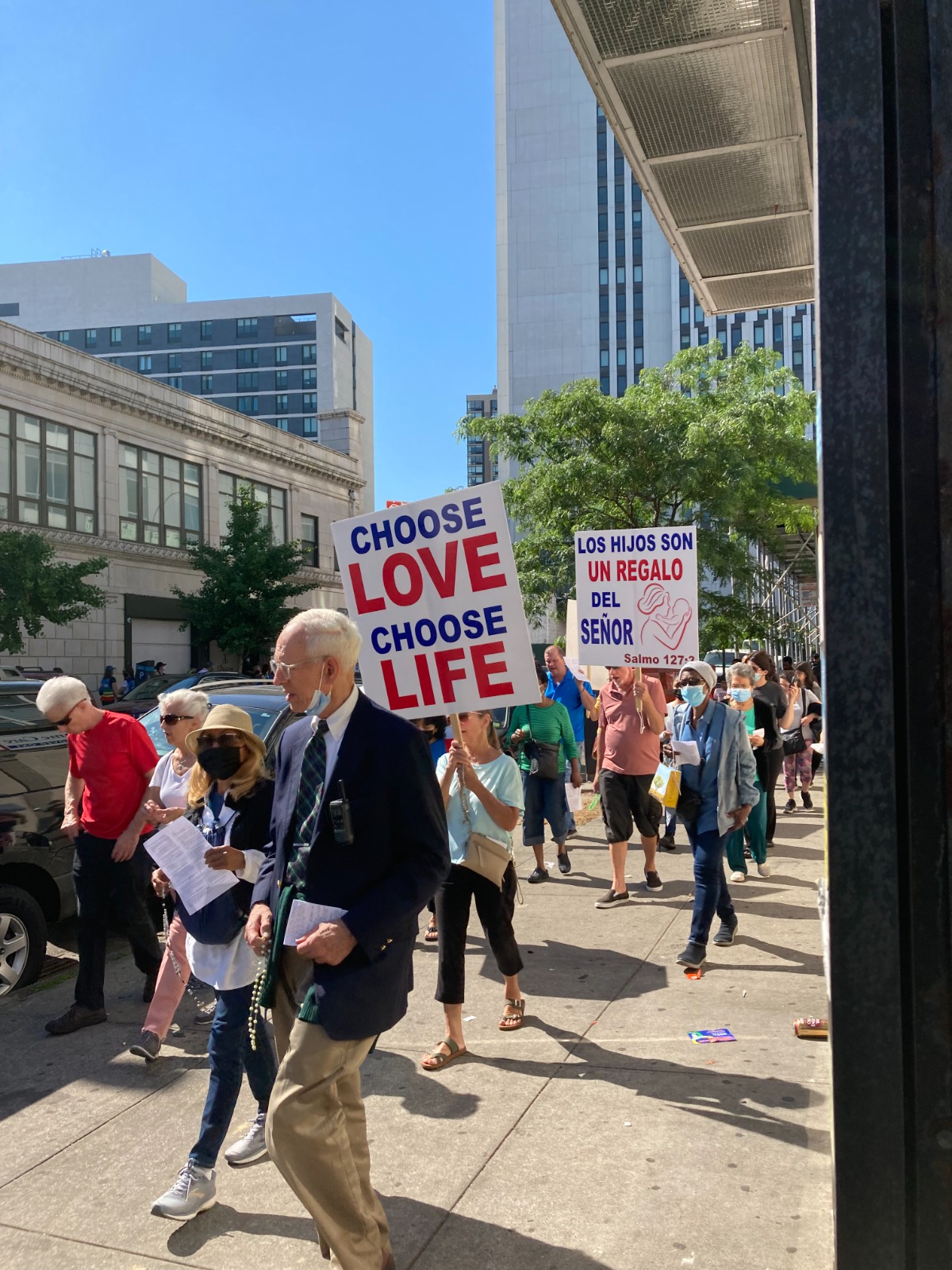 A man holding a sign that says " choose love, choose life ".