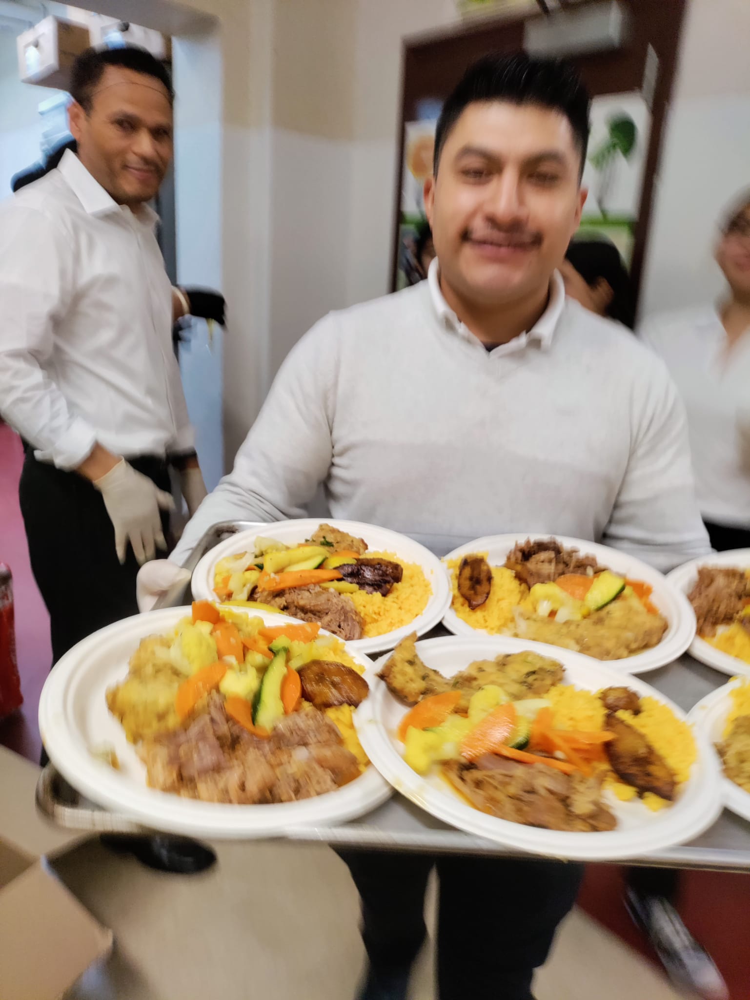 A man holding plates of food in front of him.